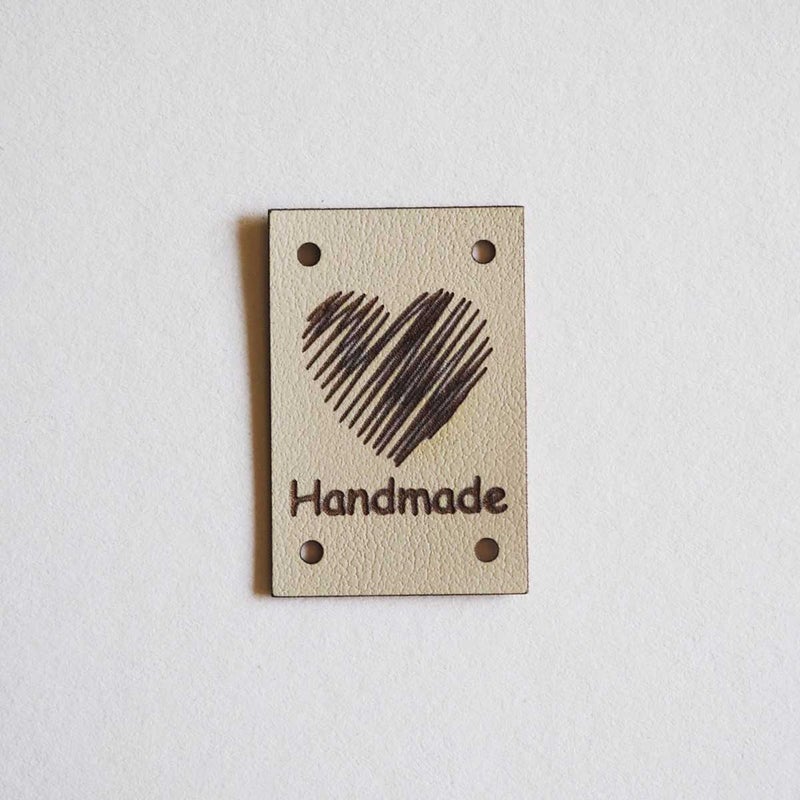 Keinonahkainen Handmade-ompelumerkki syd&auml;nkuviolla